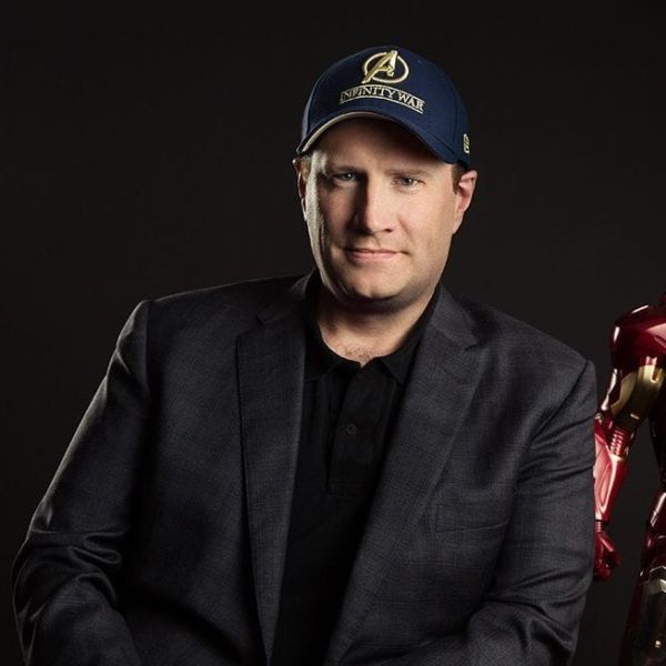 Kevin Feige wearing a black suit and a face cap