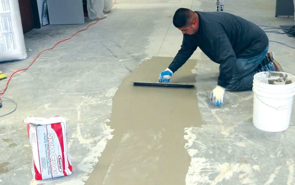man skim coating the floor 