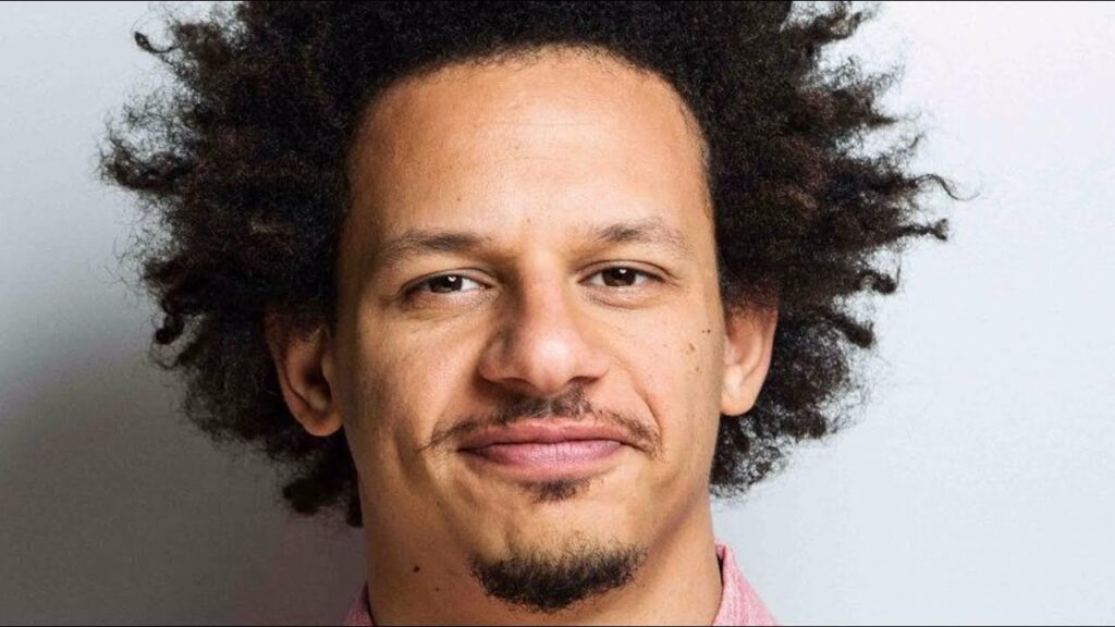 Eric Andre smiling in front of the camera with his full hair