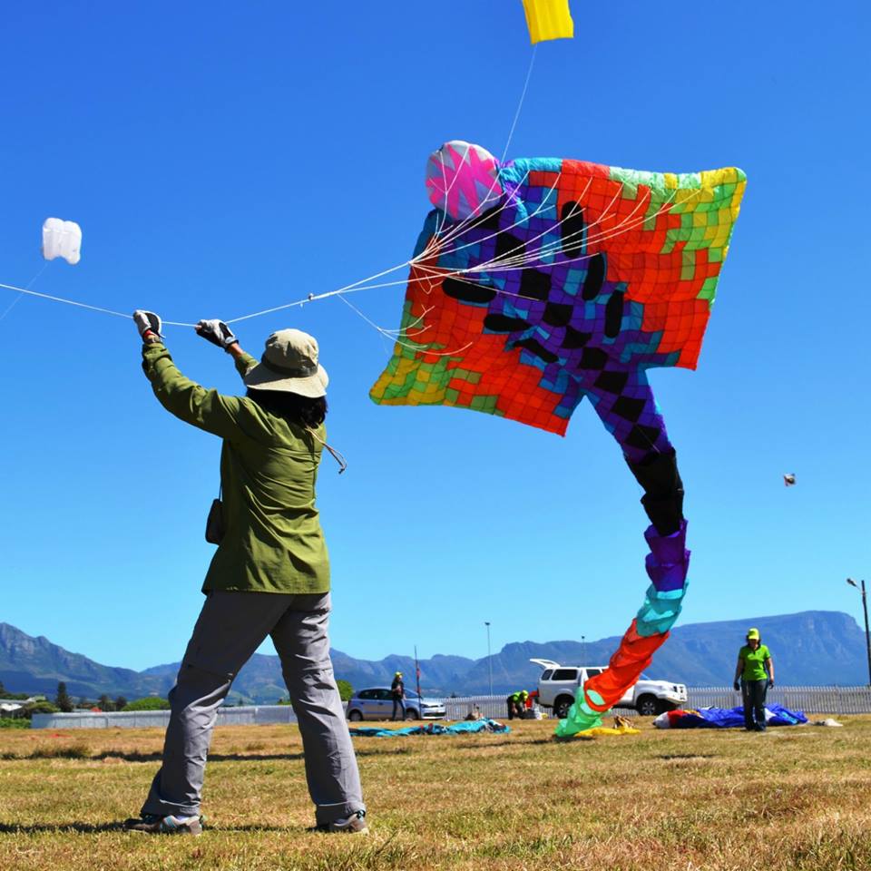 a man flying a triangular kite with different colors