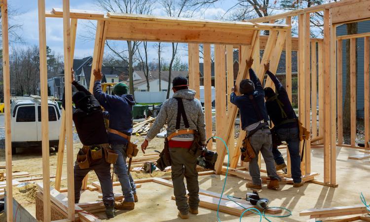 workers using 2x4 for framing in construction