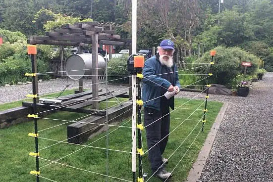 man building up an electric fence