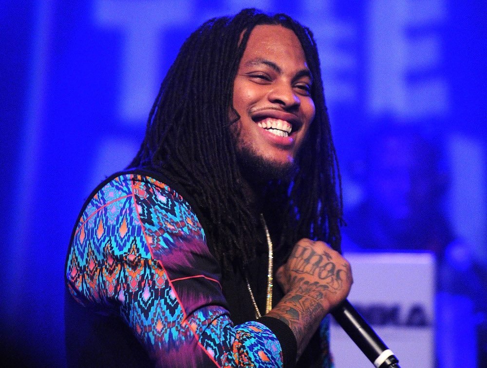 waka flocka holding a microphone while performing on stage