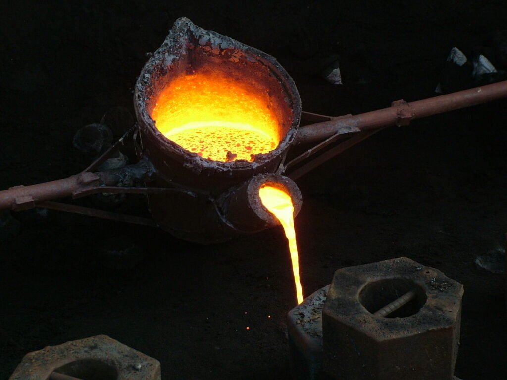 poring molten metal into a mould