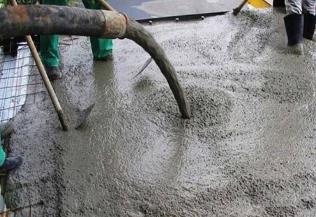 workers compacting concrete using a vibrator