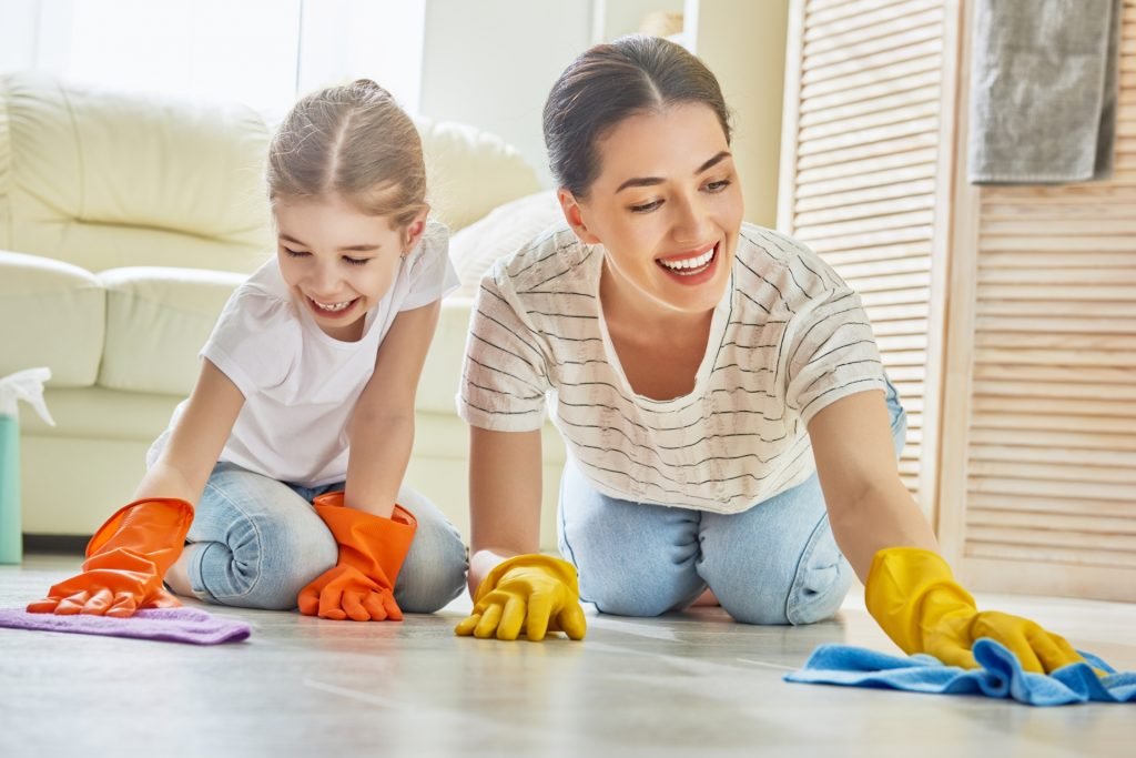 mother and daughter wearing gloves while cleaning the floor