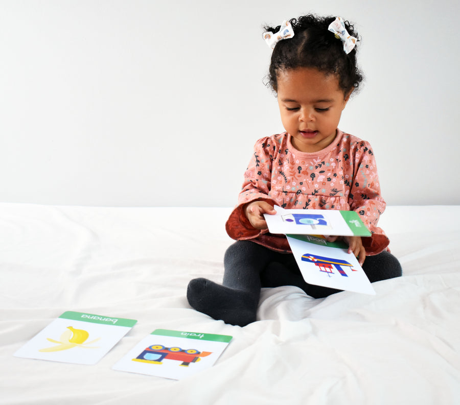 a baby using flash cards on the bed