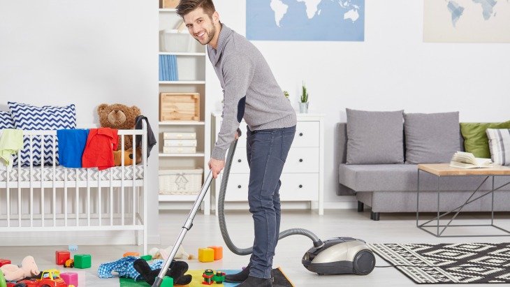 man vacuuming the carpets 
